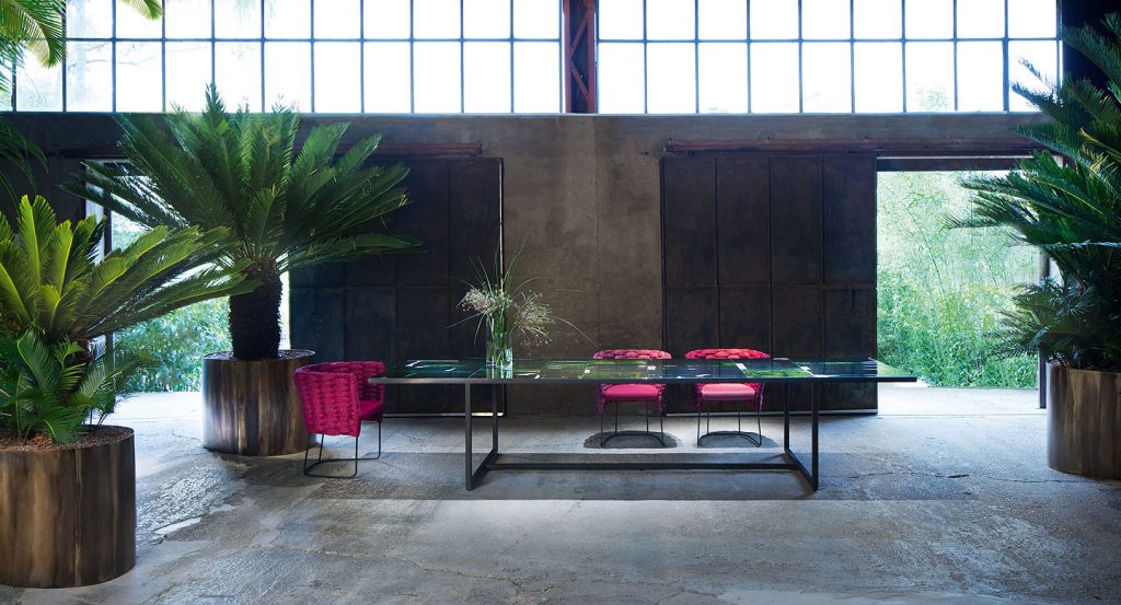 Green and black Sciara Dining Table, structure and two legs in steel, top in lava stone in a dining room.