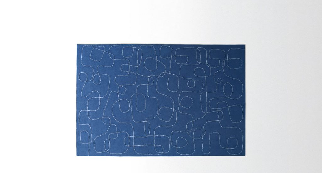 Blue and white Script rug, abstract script like pattern in wool on a white background.