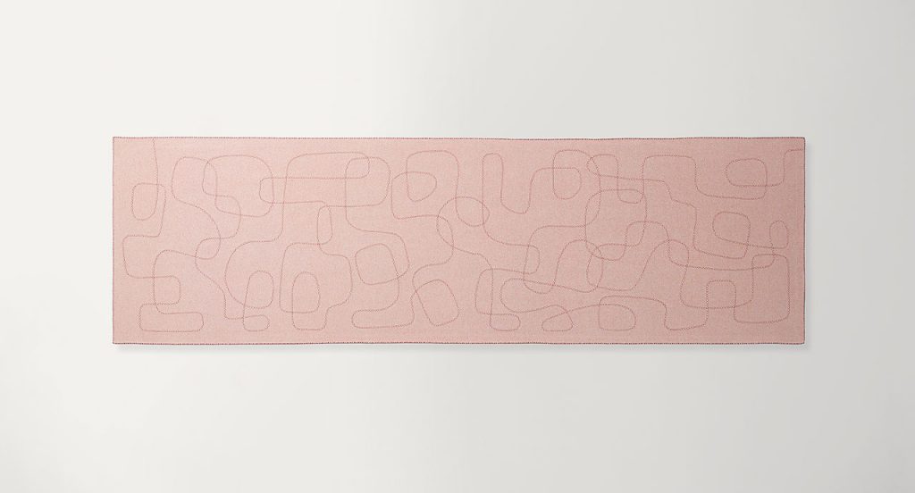 Pink Script rug, abstract script like pattern in wool on a white background.