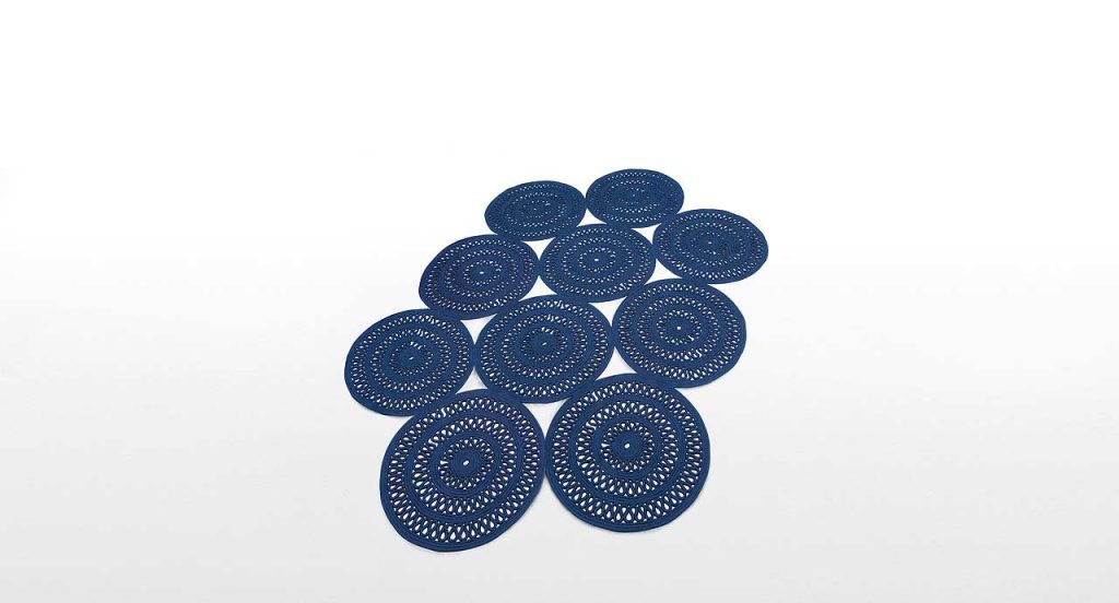 Shang Rug, round modules, blue cord in zig zag like pattern on a white background.