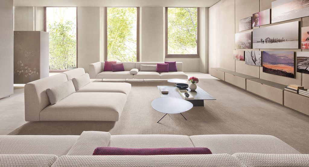 Three Move Sofas, upholstered in white fabric, two legs in steel in a living room.