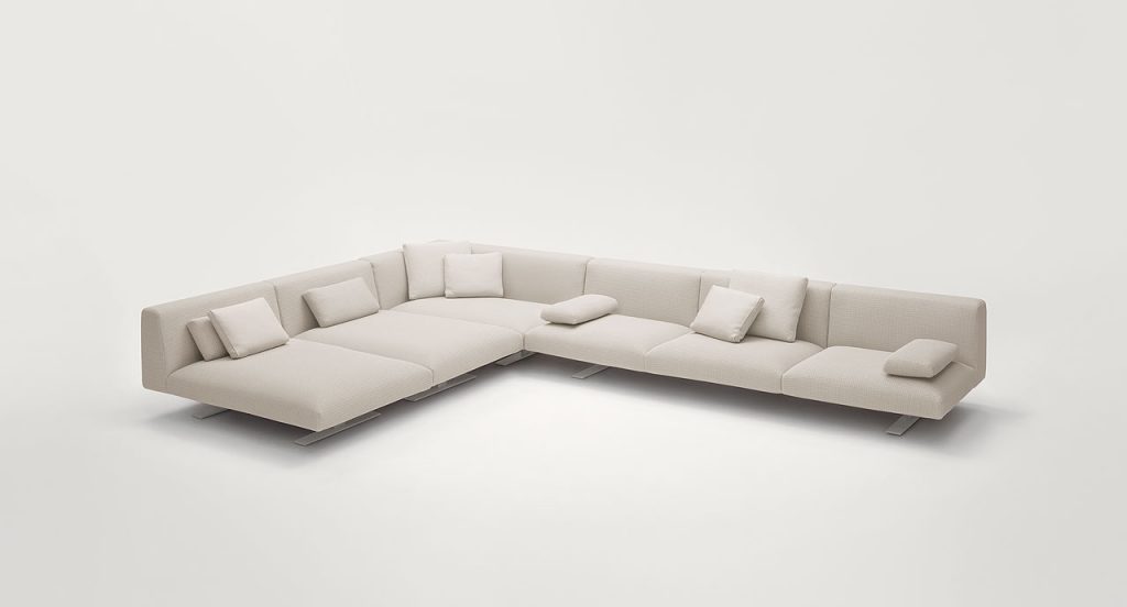 Six seater Move Sofa, upholstered in white fabric, two legs in steel on a white background.