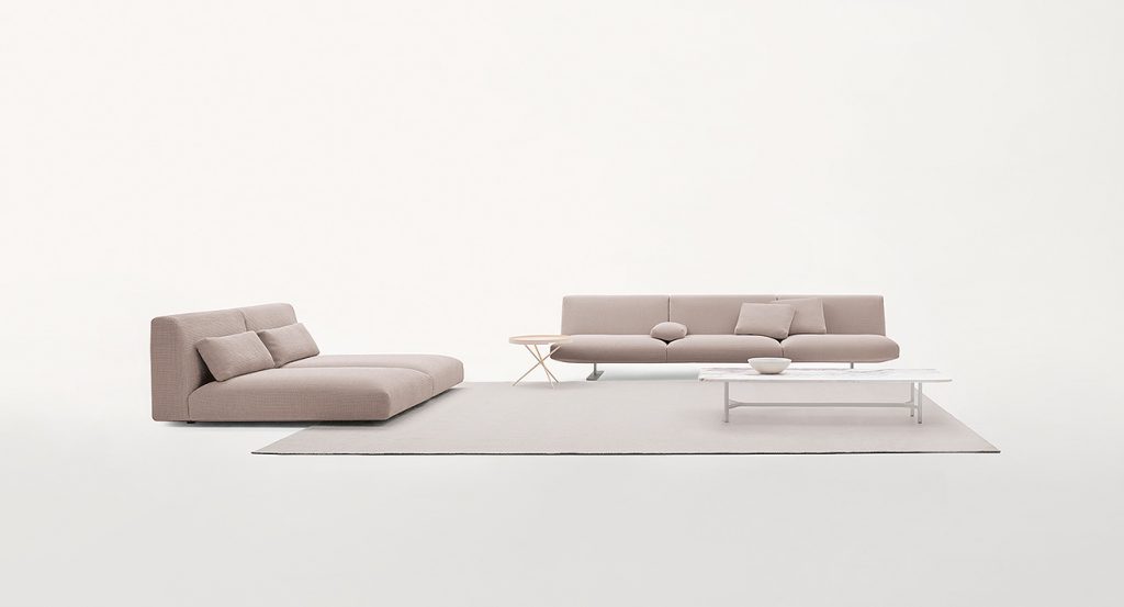 Two Move Sofas, upholstered in beige fabric, two legs in steel in a living room.
