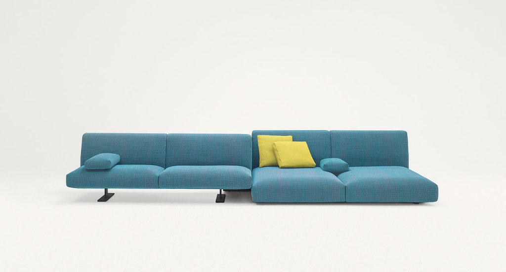 Two Move Sofas, upholstered in blue fabric, two legs in steel in a living room.