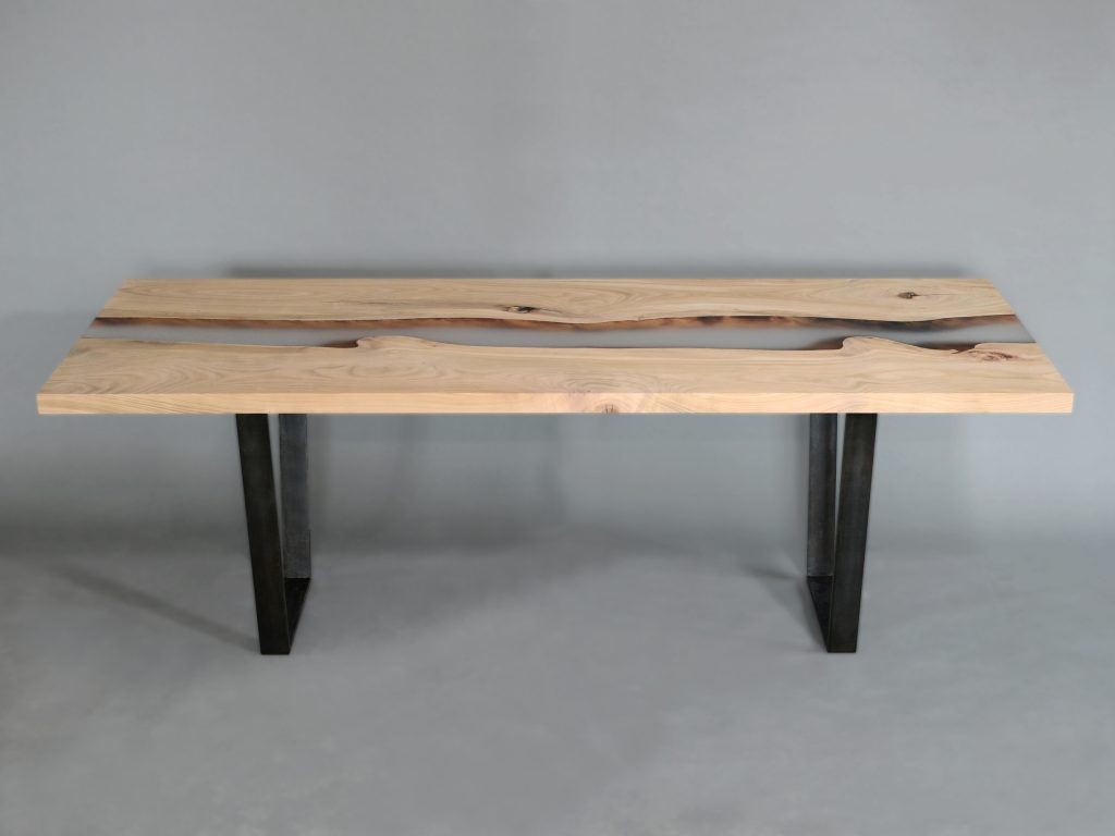 Creek Table with a rectangular shape, made of solid walnut wood with a natural finish and featuring a transparent resin inlay, set against a white background.