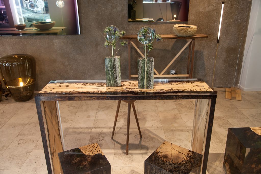 Bent Console with an elongated shape, made of solid wood with a natural finish and featuring a transparent resin inlay, in a living room.