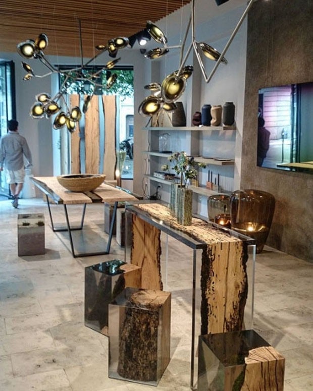 Bent Console with an elongated shape, made of solid wood with a natural finish and featuring a transparent resin inlay, in a showroom.