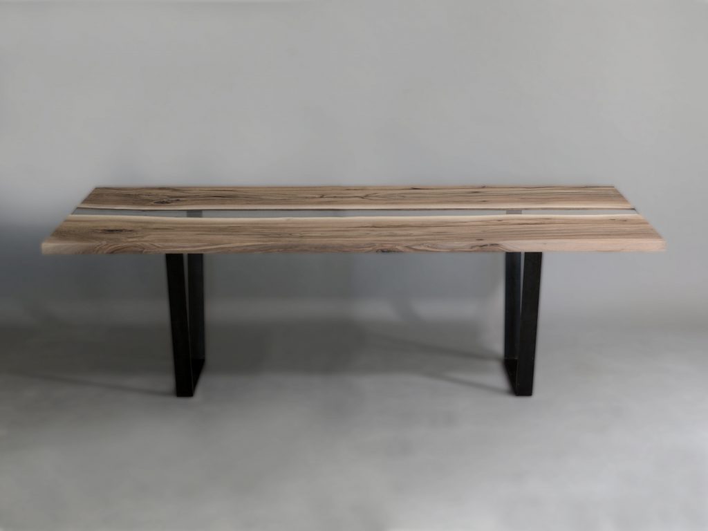 Creek Table with a rectangular shape, made of solid walnut wood with a natural finish and featuring a transparent resin inlay, set against a white background.