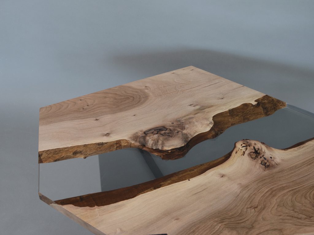 Closeup of Crystal Walnut Low Table with a polygonal shape, made of solid walnut wood with a natural finish and featuring a transparent resin inlay, set against a white background.
