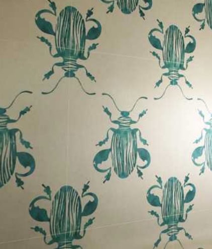 Closeup of Scenery mosaic in yellow with green bugs pattern on a wall.