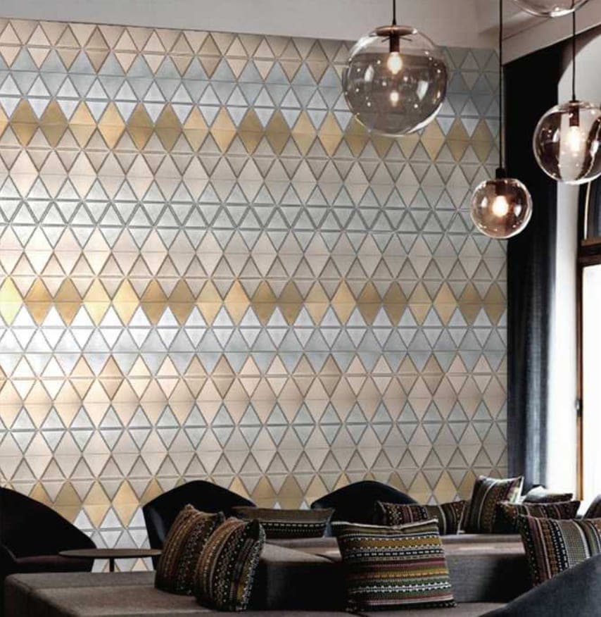 Trinity mosaic in yellow and white with a triangular pattern, set against a wall in a living room.