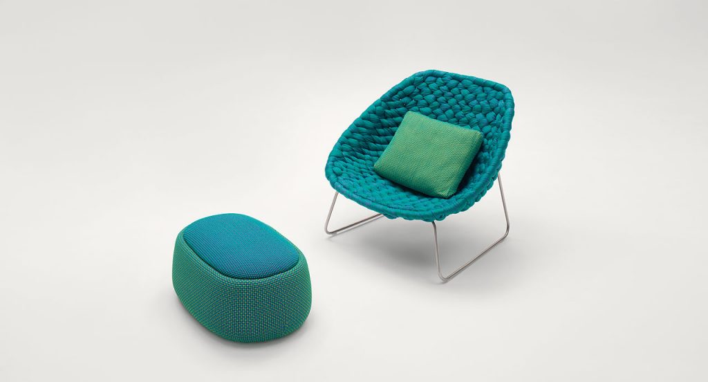 Shito Indoor Amrchair structure and two legs in steel, upholstery in blue woven tubular knit on a white background.