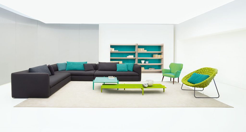 Shito Indoor Amrchair structure and two legs in steel, upholstered in green tubular knit in a living room.