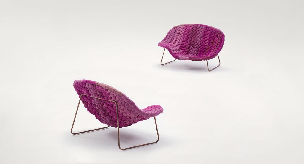 Two pink Shito Indoor Chaises, structure and two legs in black steel, upholstey in outdoor tubular knit on a white background.