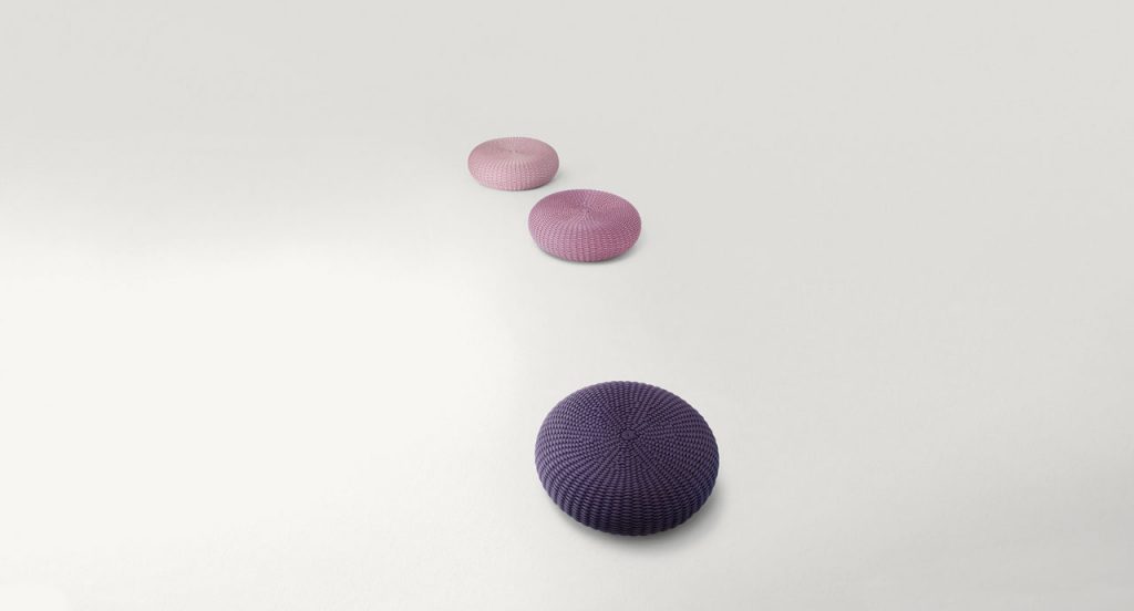 Three Shell poufs, upholstery in rope cord, two in pink, one in purpure on a white background.