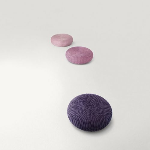 Three Shell poufs, upholstery in rope cord, two in pink, one in purpure on a white background.