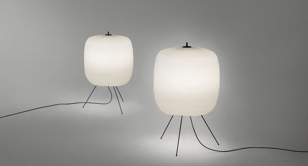 Two Shoji floor lamps, cover in semi transparent polyester cord and three black steel legs on a white background.