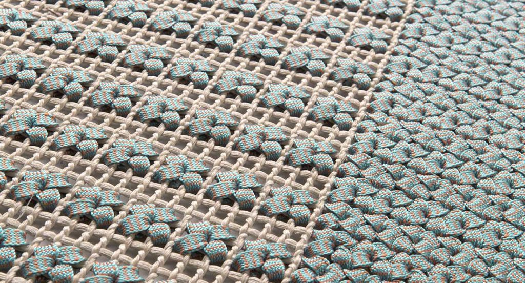 Siepe rug, embroidery made of flat braid in kimia blue and brown fabric.