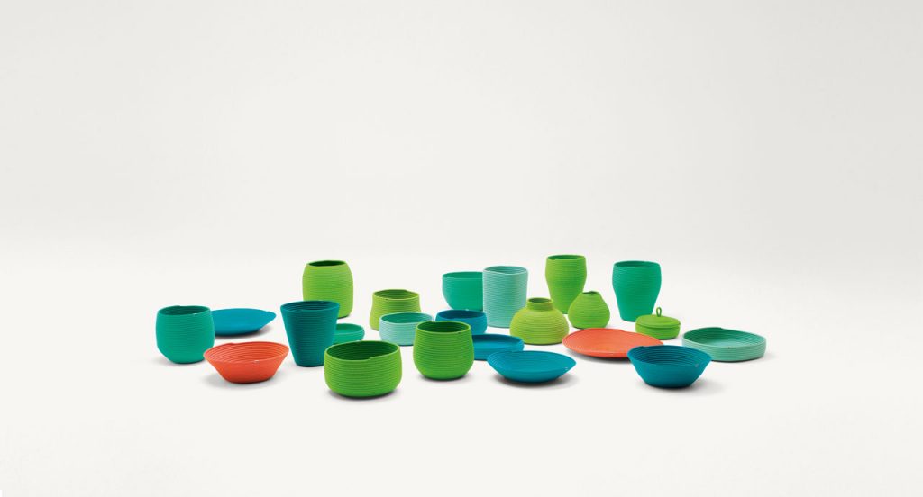 Sika baskets, vases, bowls and planter covers with different form and dimension made with a Rope cord, nine in blue, twelve in green, two in orange on a white background.