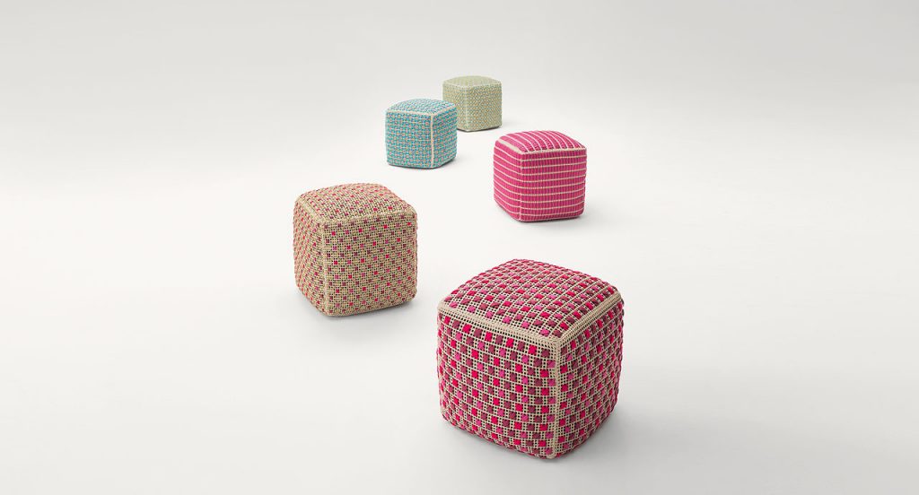 Four Spezie poufs embroidered. Three in pink, one in blue and one in green on a white background.