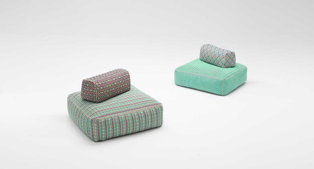 Four Spezie poufs embroidered. Three in pink, green and blue and one in blue on a white background.
