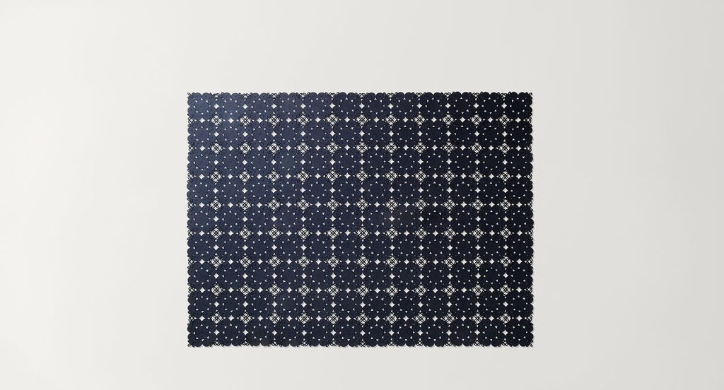 Spin Modular Rug made of black sewn spirals and leaves on a white background.