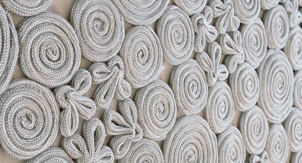 Spin Rug made of white sewn spirals and leaves on a white background.