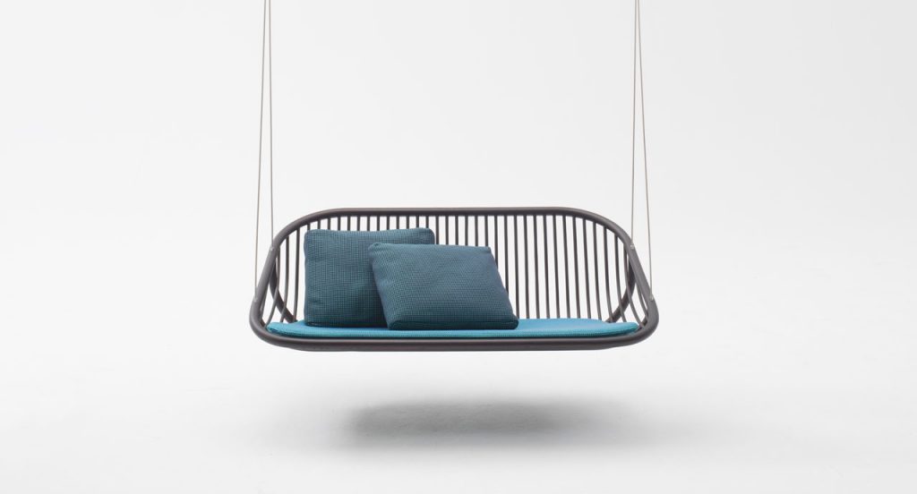 Swing suspended seat, structure in brown wood, seat pad, loose cushions on blue and suspension cords on a white background.