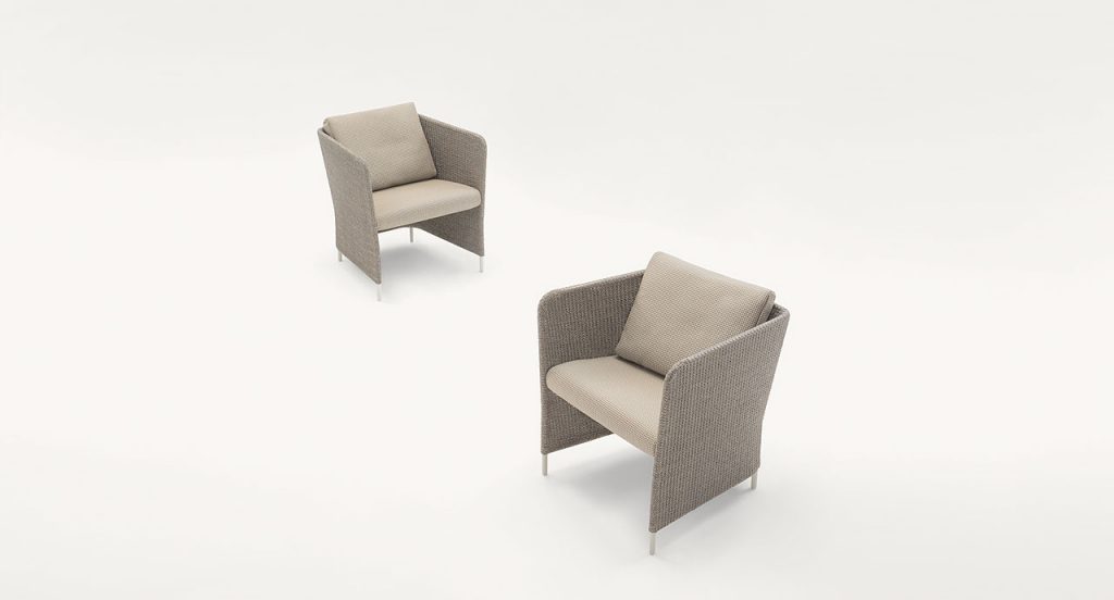 Two brown Teatime Armchairs, upholstery in Thuia fabric, two cushions and four steel legs on a white background.