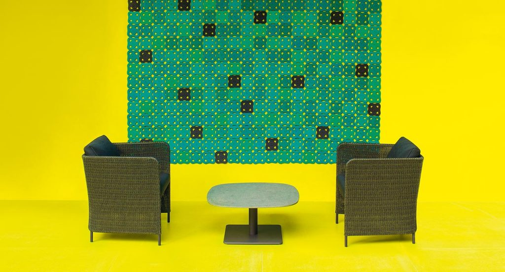 Two brown Teatime Armchairs, upholstery in Thuia fabric, two cushions and four steel legs in a living room.