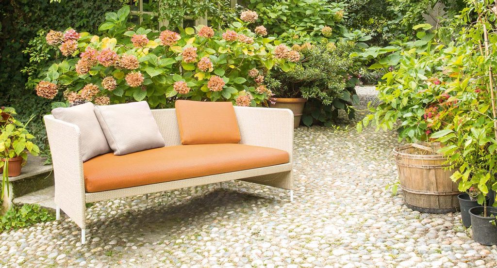 White and orange Teatime Sofa with armrest. Upholstery of braids in rope in the countryside.
