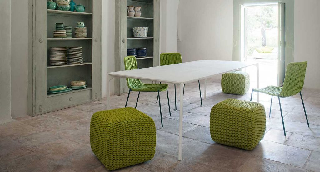 Three green Tide poufs, upholstery woven with Rope cord in a dining room.