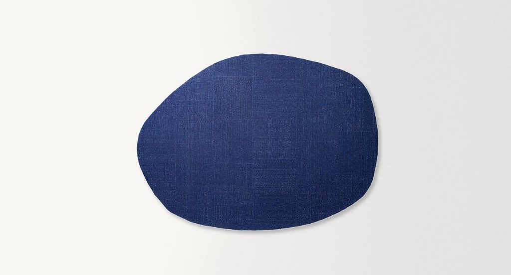 Oval Tweed rug by joining large square elements with a polyester yarn on a white background.