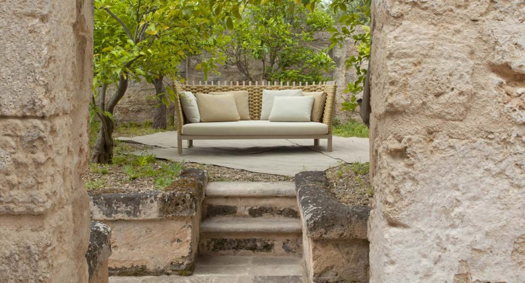 Wavi sofa, structural melange weave and wood in natural color, white seat cushion in the countryside.