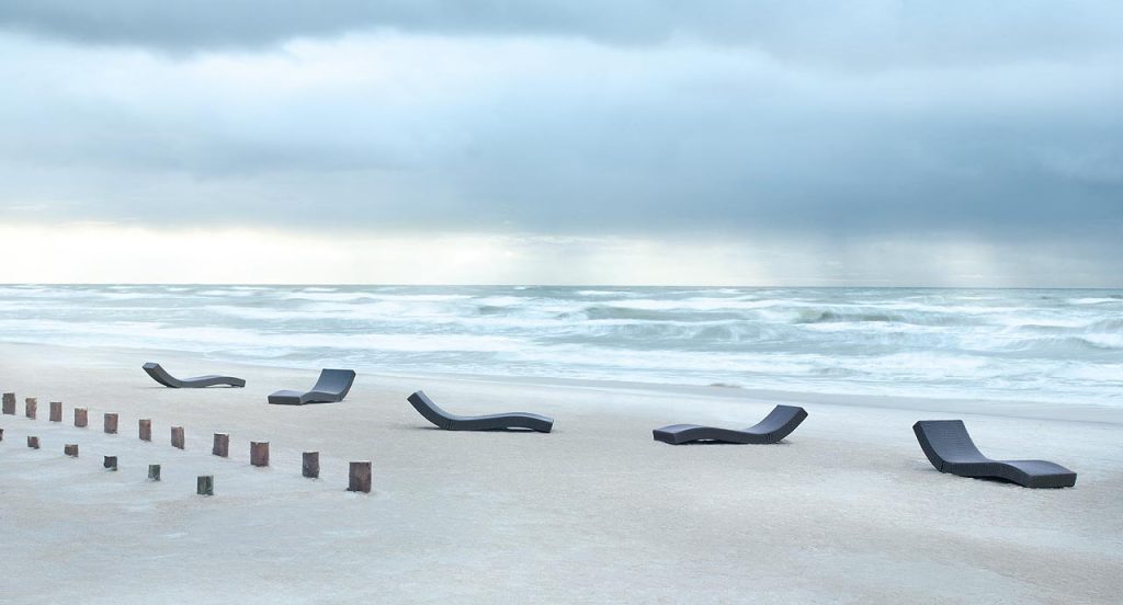 Five blue Wave chaise loungers in rope cord on the beach.