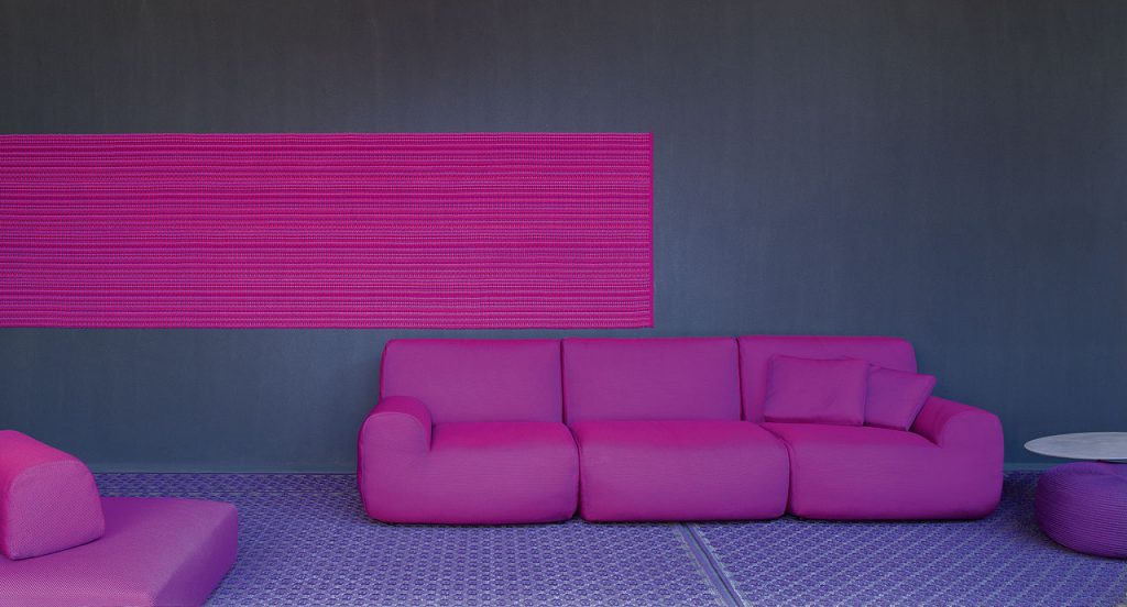 Pink Welcome modular seating system with armrest backrest, three seats, in a living room.