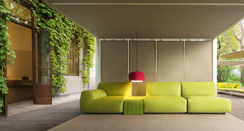 Green Welcome modular seating system with armrest backrest, three seats and a pouf in a living room.