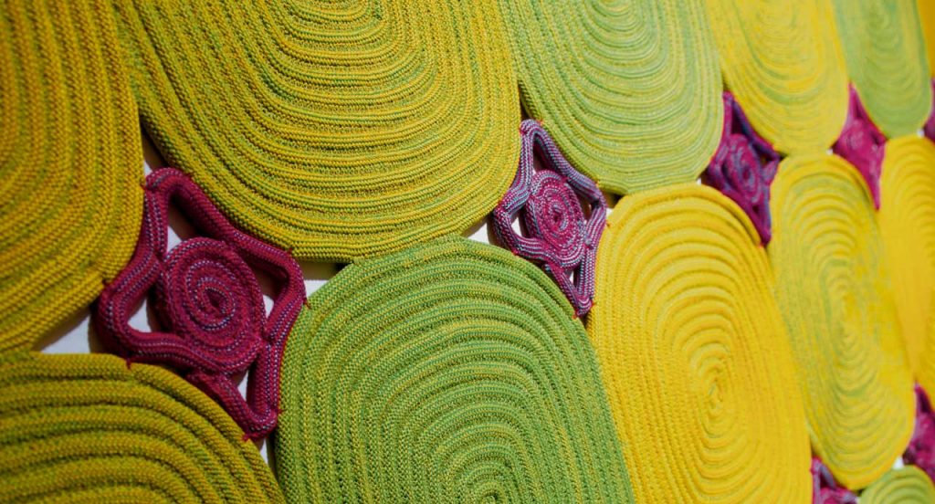 Zoe Natural rug wool cord, square modules in color green, yellow and pink.