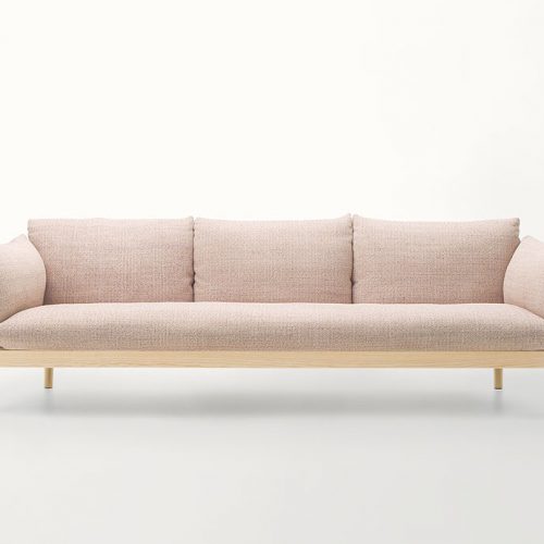 Three seater Tapio Sofa, structure and four legs in natural wood, upholstery in pink fabric on a white background.