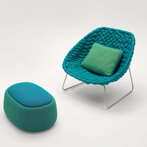 Green and blue Shito Indoor Pouf, upholstery in fabric nexto to a chair on a white background.
