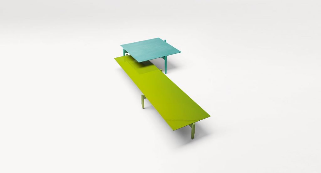 Two Tapio Side Table, left in green, right in blue. Ash heartwood structure and top in wood fiber with four legs on a white background.