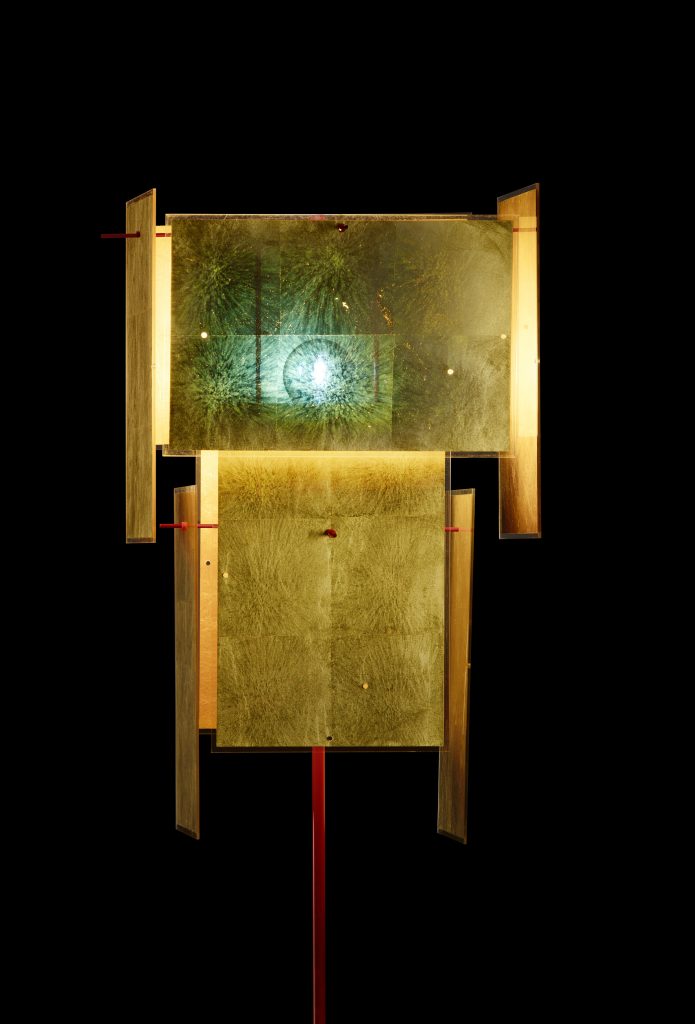A 24 Karat Floor lamp standing in front of a black background