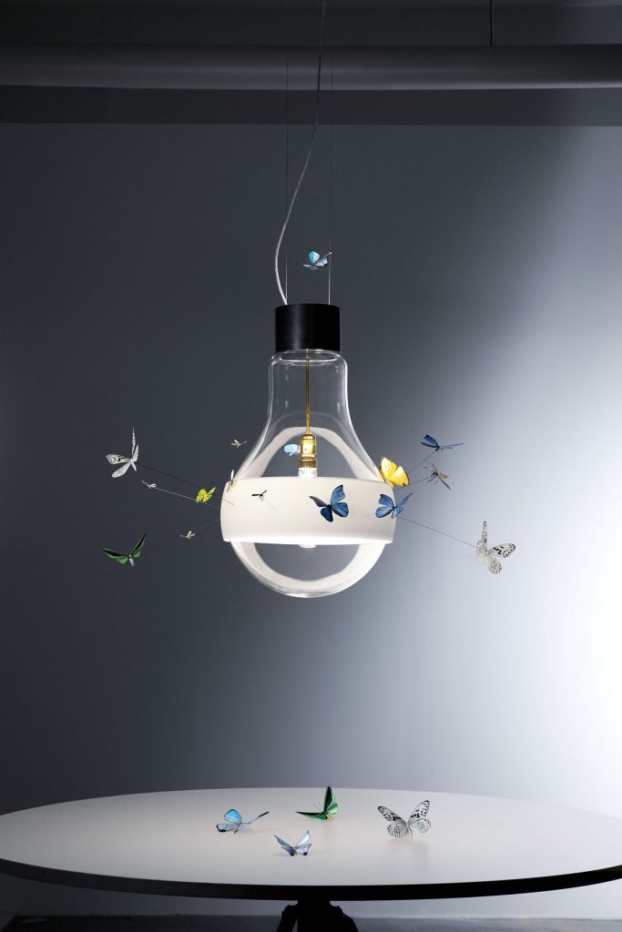 Butterflies dreaming shows a lightbulb with butterflies surrounding it over a table