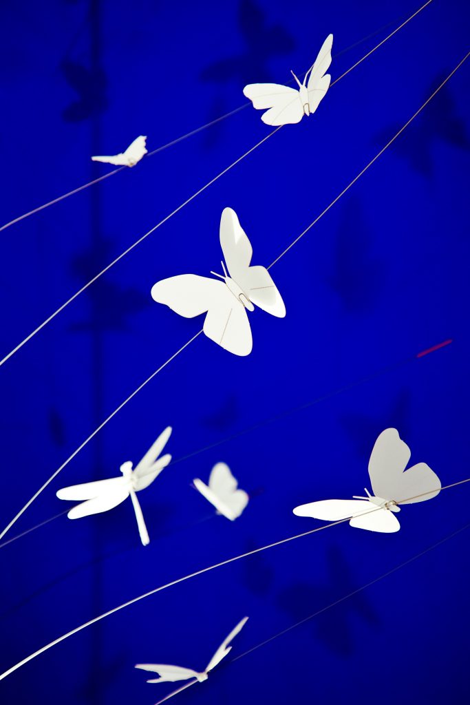 La Festa delle Farfalle light with a blue background and white butterflies