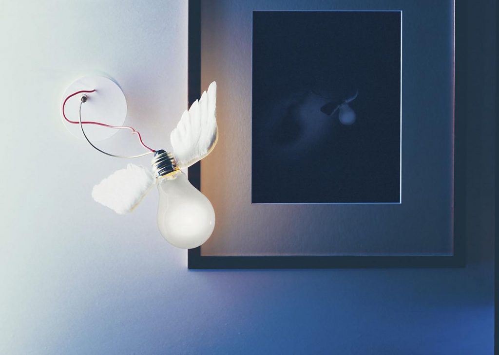 A Lucellino Wall light that is mounted on a blue wall with a picture next to it