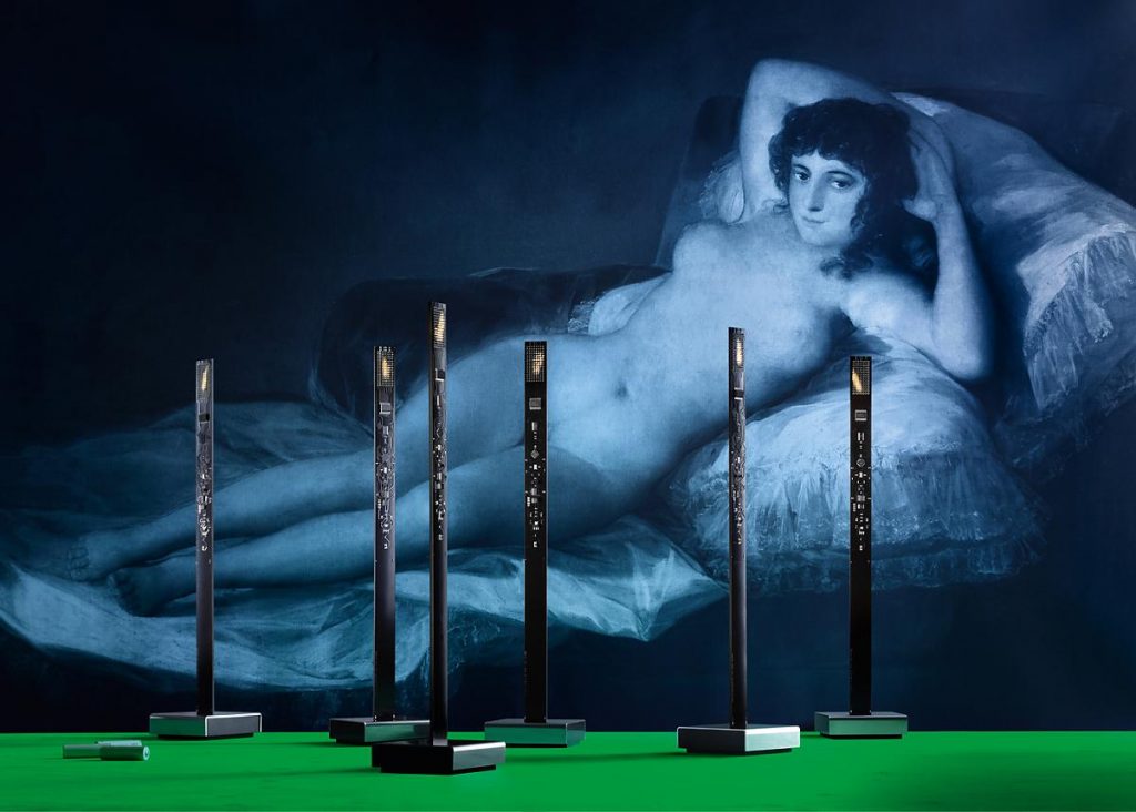 A woman painting in the background with a table in front with My New Flame on top of the table