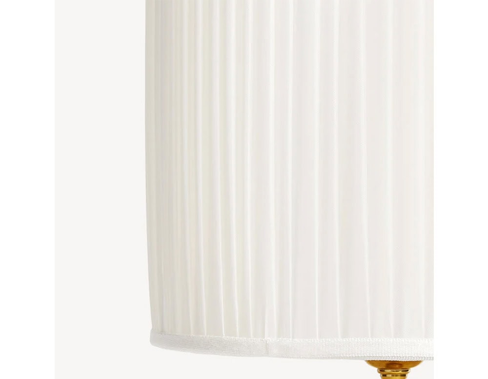 Elegant cylindrical lamp shade with subtle pleating in crisp white fabric, designed to complement classic or contemporary interiors with soft, even light.