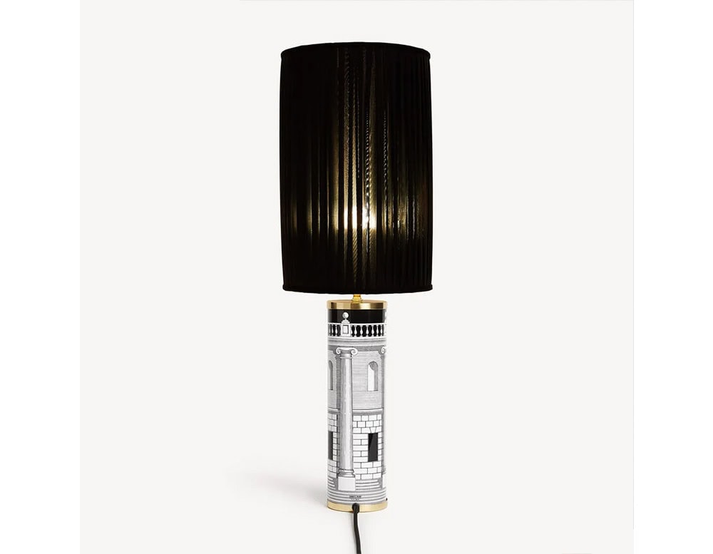 Striking table lamp with a cylindrical base adorned with intricate black and white design and a sleek black pleated shade for a dramatic statement.
