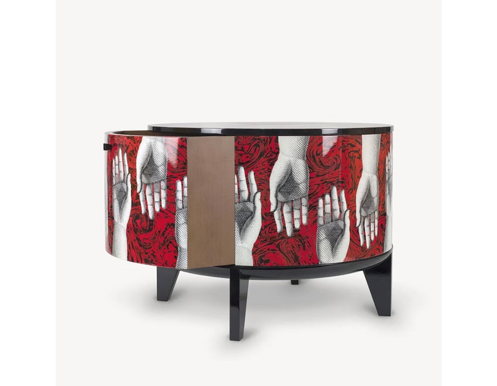 A round side table featuring vivid red swirls and intricate hand illustrations with a sleek door panel, merging functional storage with bold artistic design.