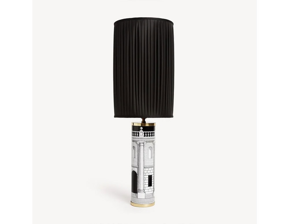Elegant lamp combining a cylindrical base with black and white architectural detailing and a tall pleated black shade, creating a dramatic and refined statement piece.